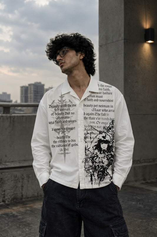 A man wearing a white long-sleeve button-up shirt with black graphic text and illustration prints, paired with dark cargo pants, standing outdoors on a rooftop with a city skyline in the background.