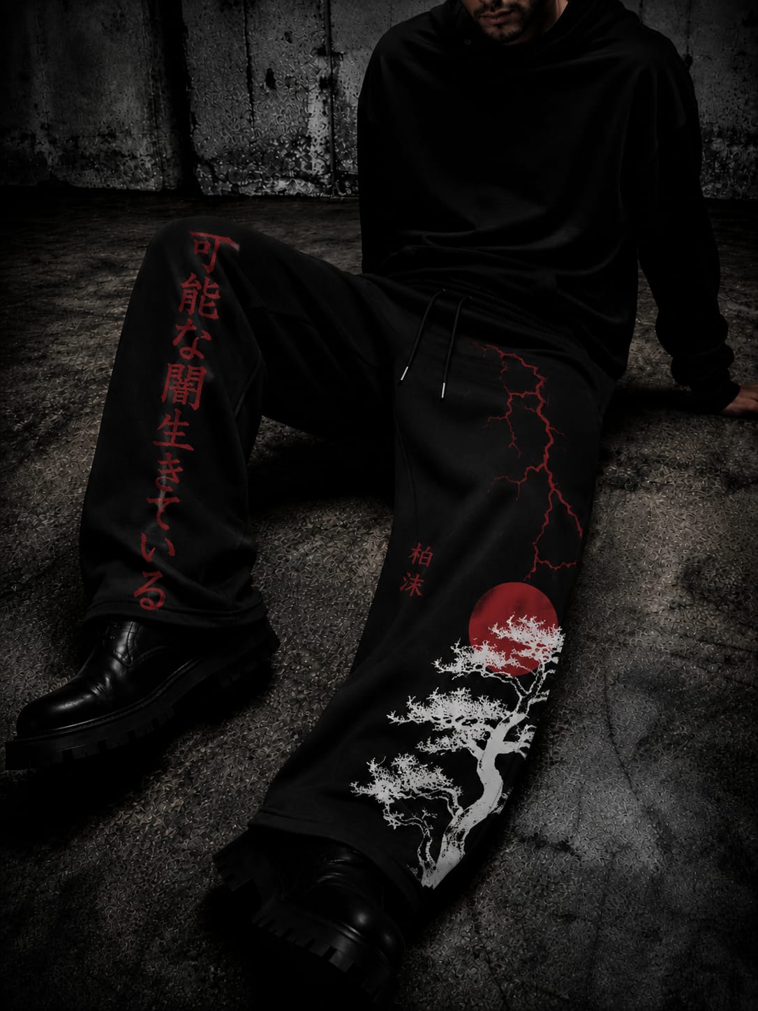Black gothic-style wide-leg pants featuring red Japanese lettering, red lightning graphics, and a white tree design, styled with black boots.