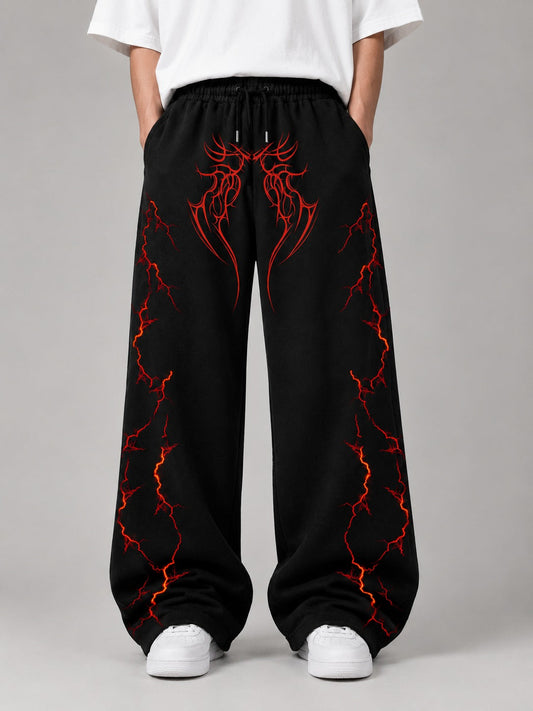Black wide-leg sweatpants with a red and orange lightning-bolt graphic pattern, modeled with a white t-shirt and white sneakers against a gray studio background.
